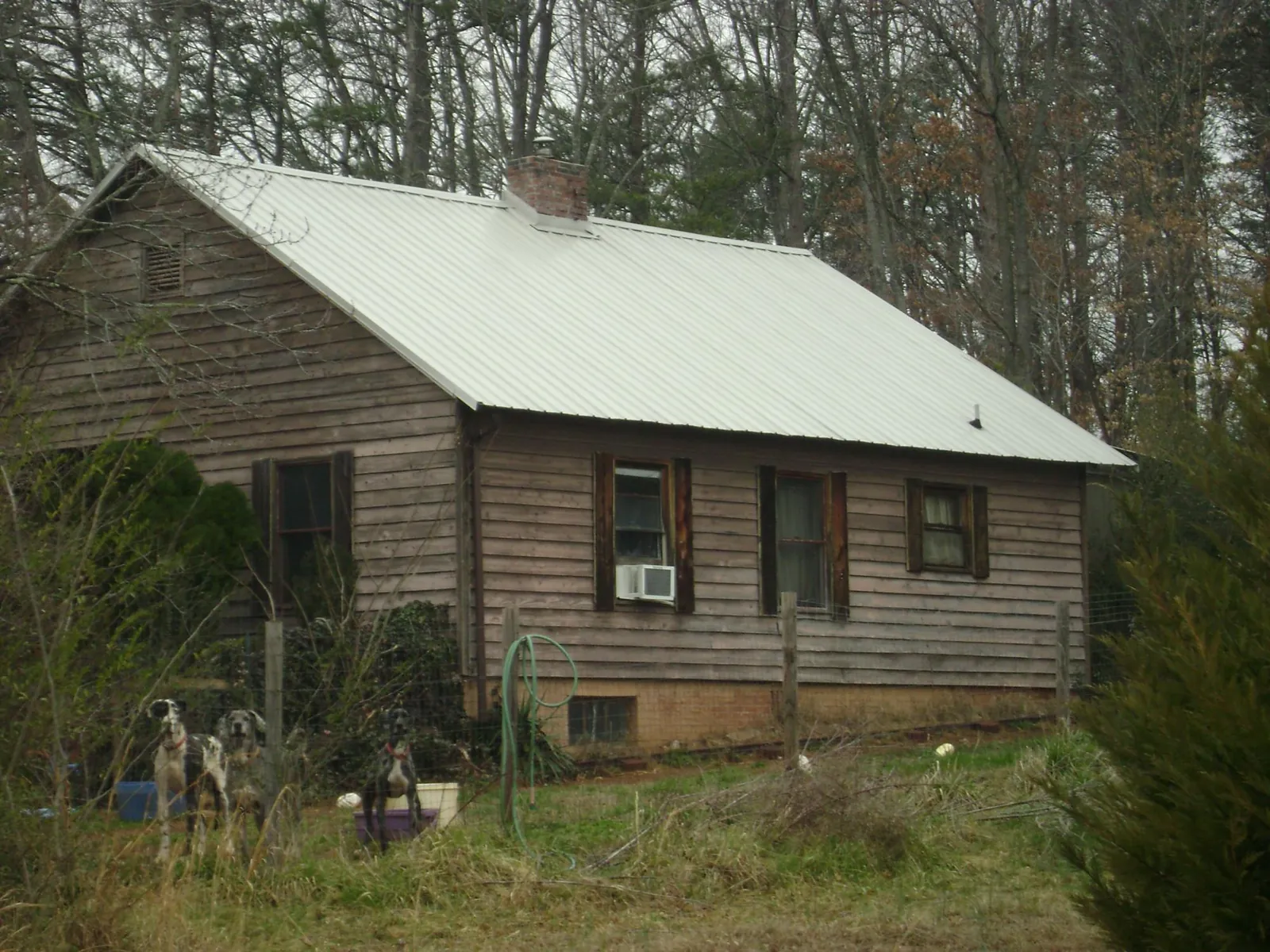 White metal roof on an old wood sided farmhouse, from a Metal Roof Installation job in Bedford